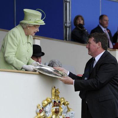 Colin Rayner receives silver plate from the Queen
