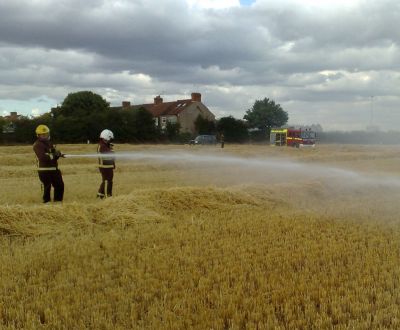 Firemen Extinguishing Rape Crop Fire
